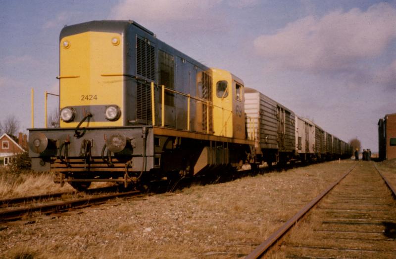 Hier ‘de laatste trein op de oostelijke tak' te Hallum. Wat de liefhebbers niet konden weten, was dat de ZPC de NS onder grote druk zette om nog één seizoen de oostelijke tak te mogen gebruiken voor de afvoer van de pootaardappelen. In het eerdergenoemde boek is de strijd tussen de NS en ZPC uitgebreid beschreven. Na veel touwtrekken streek de NS de hand over het hart en was het seizoen 1974/1975 het allerlaatste. Saillant detail: ook de 2424 reed de laatste trein van Holwerd naar Leeuwarden, eind januari 1975. Foto: Wietse Hoekstra.