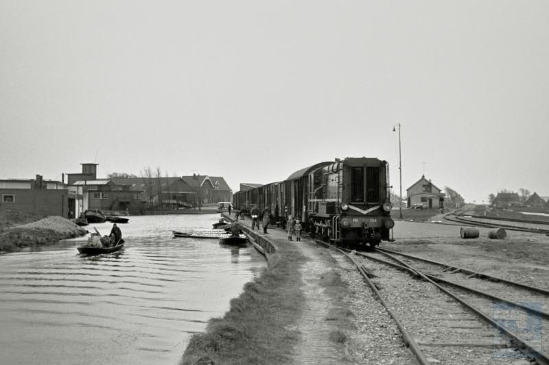 We blijven nog even in Noord-Holland.We zien loc 534 met een buurt­goederen­trein in Noord-Scharwoude; rechts het spoor naar Heerhugowaard. Deze situatie heeft tot 1973 bestaan. Per boot werd witte kool aangevoerd om verder per trein te worden getransporteerd.In deze streek werd veel groente per boot aangevoerd, zoals nog te zien is in het museum "de Broeker Veiling" te Broek-op-Langendijk.
