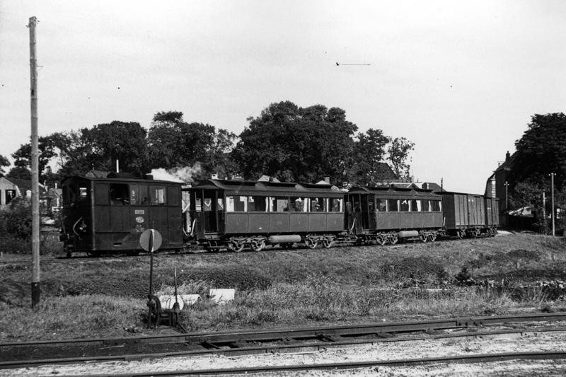 Op 3 oktober 1936 nadert NTM locomotief 36 met personenrijtuigen BC 6 en BC 5 en met enkele goederenwagens het station Heerenveen. De tram komt uit de richting Drachten, via toen de nieuw aangelegde omleidingsroute buiten de bebouwde kom van Heerenveen om. De foto werd gemaakt door L.J. Biezeveld.