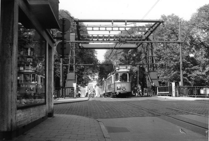Het afscheid van de Utrechtenaren in Amsterdam kondigde zich in het jaar 1960 al duidelijk aan. Ook de oude Weesperstraat, of liever gezegd wat daar nog van over was, zou al spoedig moeten wijken voor de aanleg van een brede autoweg. Op deze foto van Ab van Donselaar van 18 september 1960 is daarvan nog weinig te zien. Wat een rust gaat er uit van dit tafereeltje rond de vroegere brug over de Nieuwe Herengracht, met op de achtergrond het nog ongeschonden Jonas Daniël Meijerplein. Het tramstel op de brug bestaat uit motorwagen 308 (eens nummer 68 in de Domstad) en bijwagen 777. Een jaar later zou de tram hier voor het laatst rijden. Ook de nieuwe brug op deze plaats was aanvankelijk van tramspoor voorzien. Niettemin zou de tram hier niet meer terugkeren.