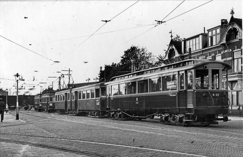 Op 14 september 1940 wachten op de Rijnsburgerweg te Leiden enkele NZH-trams tot een ongetwijfeld langzaam rijdende goederentrein de overweg is gepasseerd. Op deze foto van P. Brouwer zien we vooraan tramstel A611+612 met aanhangrijtuig B23.