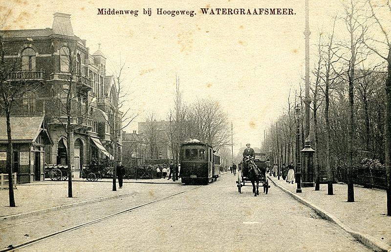 Rond 1915 staat de Gooische Stoomtram aan de halte nabij het Hoofdkantoor van de GS aan de Middenweg in Amsterdam. Achter dit gebouw, dat overigens nog steeds bestaat en inmiddels in oude luister is hersteld, bevond zich de remise en de werkplaats. Tegenwoordig rijden hier de Combino′s van lijn 9. Verzameling Ab van Donselaar.