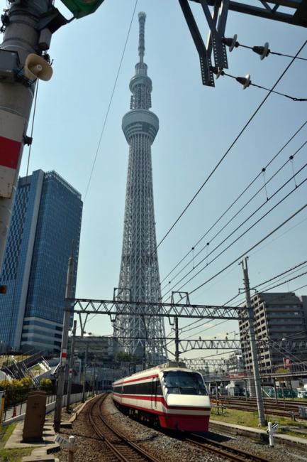 Een trein van de Tobu Railway passeert op 13 april 2013 de 634 meter hoge skytree. De sneltreinreeks 200 series Ryômô limited express, die ingezet wordt op de Tobu Skytree Line, is hier op weg naar Kuzû.