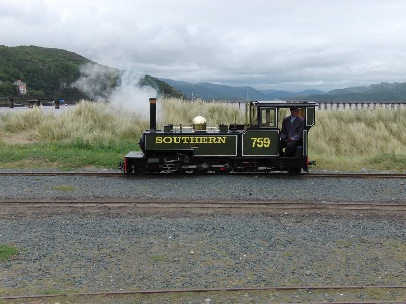 Van Fairbourne kun je op meerdere manieren in Barmouth komen. Met de reguliere trein over de 820 meter lange houten Barmouth Bridge. Of met de twee mijl lange en 12,25 inch brede Fairbourne Steam Railway door de duinen en met een motorbootje naar Barmouth. Vanaf het eindpunt tegenover Barmouth is op de achtergrond de Barmouth Bridge over de Mawddach Estuary te zien. Locje Yeo liep om; een replica schaal 1:2 van een smalspoorloc uit Cornwall.