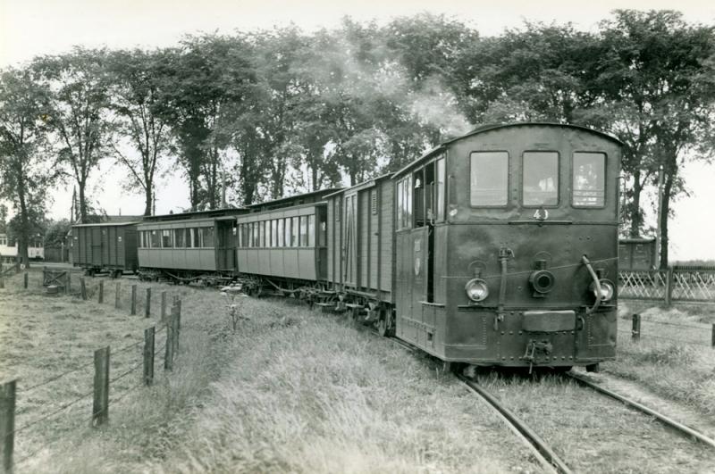 De paardentram was niet opgewassen tegen de enorme concurrentie van de autobussen. Daarom wilde de NTM de lijn al midden jaren twintig sluiten. De Provincie Friesland verbood dit. Uiteindelijk stemde ook de gemeente Dantumadeel in met de komst van stoomtrams en motorwagens. De lijn werd verzwaard en op 15 mei 1926 feestelijk in gebruik genomen. Hier een stoomtram met loc 40 in augustus 1936 te Veenwouden met een tram naar Dokkum. Foto: J.J.B. Vellekoop.