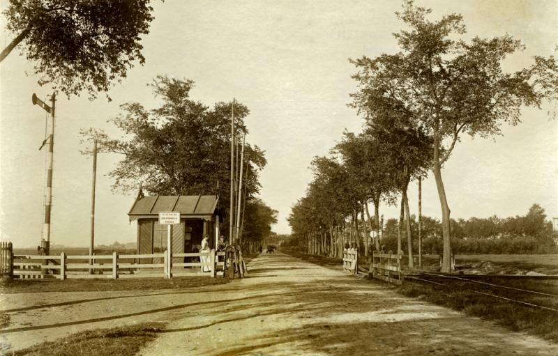 We bevinden ons nog steeds op de Harlingerstraatweg en we kijken in de richting Marssum. Hier zien we de kruising met de NFLS-lijn Leeuwarden - Stiens - Metslawier/Tjummarum. De NFLS had bij Leeuwarden Halte enkele armseinen om de tramkruising te beveiligen. Een daarvan staat hier links op de foto die rond 1907/1908 is genomen.
