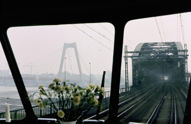 In Rotterdam werd uiteraard nog over het luchtspoor en de oude spoorbrug gereden.Links is al de nieuwe Willemsbrug te zien, die in 1981 werd geopend.