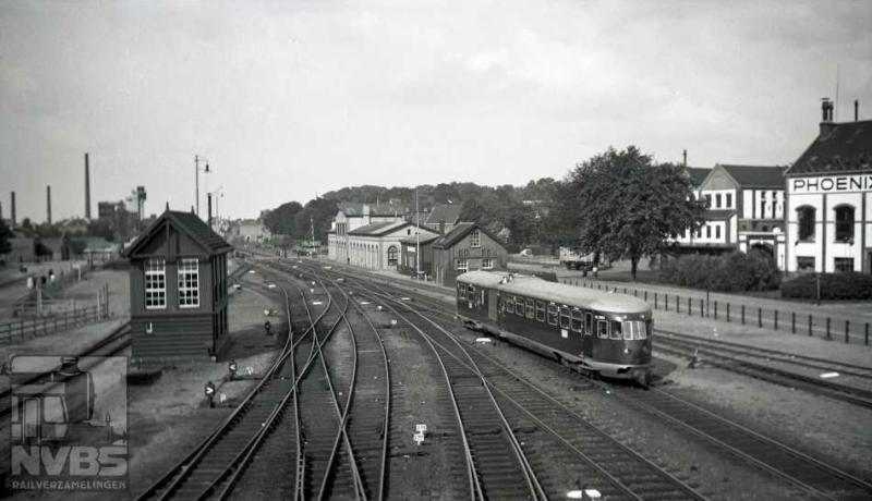 Op alle voorgaande foto's hebt u natuurlijk gezien dat er nog nergens bovenleiding hangt. In deze reportage dus geen foto's van blokkendozen of van de eerste stroomlijn-muizen. Wel van een omBC op weg naar Ede, “een van de acht” uit de serie NS 2901-2908. Zij kwamen in 1937 in dienst en waren ten tijde van deze plaat, 6-8-1939, nog vrij nieuw. Het verbrandingsmotorrijtuig passeert hier de brouwerij Phoenix, even buiten het station van Amersfoort. Zowel rijtuig als motoren waren een puur Nederlandse aangelegenheid: Werkspoor respectievelijk Stork en Thomassen. De overbrenging geschiedt mechanisch. Door de oorlog werd in mei 1940 de klok teruggezet, en verschenen er weer stoomtreinen op deze route.
