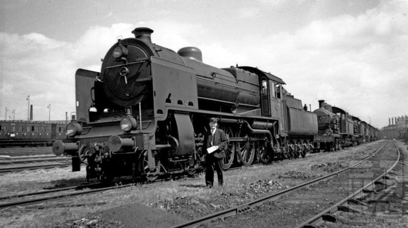 In de buurt van het locdepot staat op 5 juli 1936 een hele rij stoomlocomotieven opgesteld. Er was duidelijk iets bijzonders aan de hand. De VARA organiseerde op die dag haar zomerfeest op het landgoed Birkhoven te Amersfoort. Vooraan een loc uit de serie 3900, volgens kenners de mooiste die NS heeft gehad. Het waren er in totaal 32 (NS 3901-3932) gebouwd door de firma Henschel te Kassel. De eerste kwamen in 1929 in dienst. Doordat de maximaal toelaatbare asdruk kort tevoren was verhoogd van 16 naar 18 ton, konden de machines ook wat zwaarder worden. Dat waren de 3900-en dan ook: het dienstvaardig gewicht inclusief tender bedroeg 147 ton. Zij trokken zware sneltreinen door het land met een maximum snelheid van 110 km/h. Dit was trouwens de laatste serie stoomlocomotieven die de NS zelf heeft ontworpen. Een bijzonder scherpe foto, maar de ene buffer bedekt net het nummer zodat we dat niet kunnen vaststellen.