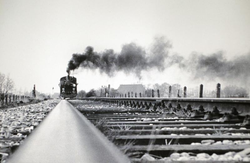 Na veel strijd knapte de NS de lijn Leeuwarden - Stiens op in het kader van een werkgelegenheidsproject en liet de ZPC een (toen) hypermodern sorteercentrum met spooraansluiting bouwen in Stiens. Om dit te vieren pendelde de eerste week in mei 1976 locomotief 21 van de Stoomtram Hoorn - Medemblik tussen Leeuwarden en Stiens, zoals hier te zien is nabij het Vliegveld Leeuwarden op 1 mei 1976. Foto: Hans Elzinga