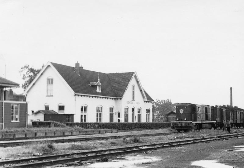 In de zomer was het rustig op de NFLS-lijnen. Het station met het meeste vervoer was dan Dokkum-Aalsum (hier met loc 2410 op 29 juli 1965), waar de lokale bedrijven druk gebruikmaakten van de los- en laadplaats. Ook was er in die tijd een brandstoffenhandel die al de aanvoer van onder meer benzine en diesel per spoor liet verzorgen. Hoewel de (toen verplichte) goederentreinconducteur in de speciale conducteurswagen (hier te zien direct achter de loc) moest plaatsnemen, gebeurde dit maar weinig. Tenzij er veel schrijfwerk te doen was, anders waren alle personeelsleden op de loc te vinden en dat was wel zo gezellig. Foto: David Mol.