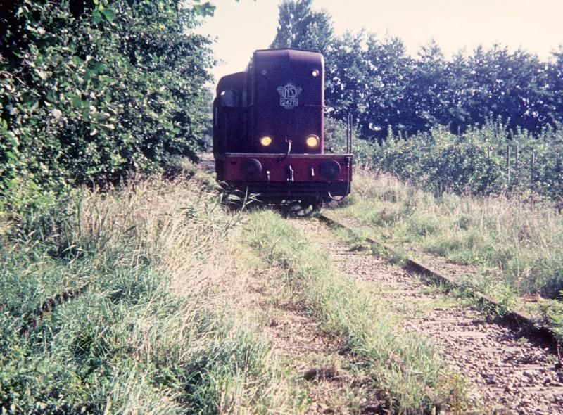 Stiens - Minnertsga was de eerste tak van de NFLS die werd gesloten. De reden: er was nauwelijks onderhoud gepleegd (en dat is te zien op de foto) en de lijn was te slecht om te berijden. Dus reed loc 2476 op 24 september 1971 de laatste trein naar Minnertsga, hier tussen St. Anna Parochie en St. Jacobi Parochie. Foto: Lieuwe van der Leij.