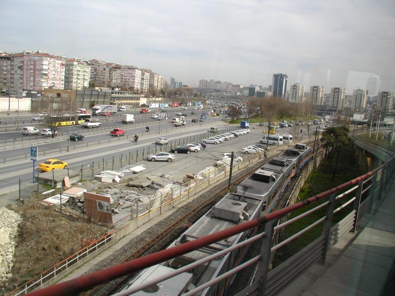 Een flink eind verder kruist de tramlijn T1 de grote ringweg; hier is ook een overstap op de metro-lijn M1, die we hier onder het viaduct door zien komen.