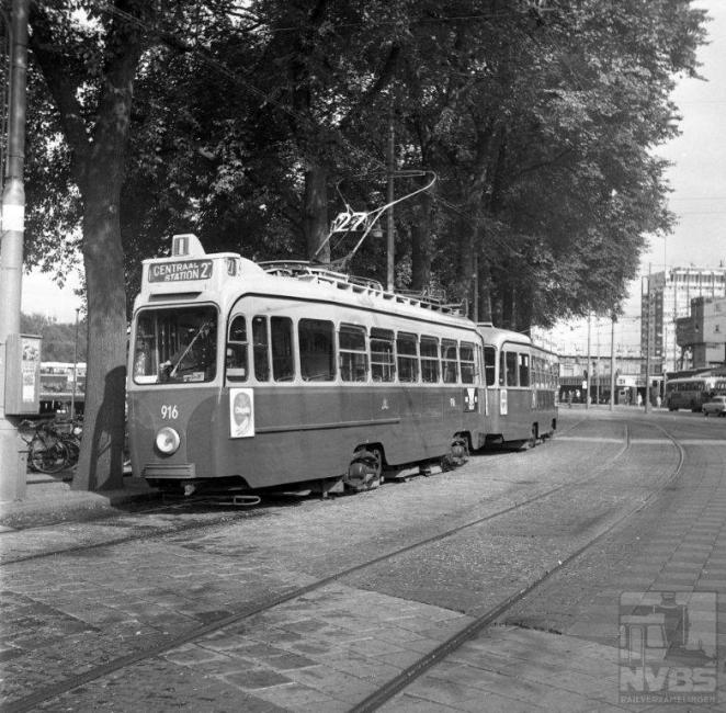 De meeste tramlijnen deden natuurlijk het Amsterdamse Centraal Station aan. De niet meer bestaande lijn 27 op deze foto uit 1968 toont een drieassig tramstel van een serie die het Gemeentevervoerbedrijf kort na de oorlog bij Werkspoor had besteld. Dit in tegenstelling tot Rotterdam en Den Haag die allebei ongeveer tegelijkertijd bestellingen deden voor vierassers. Motorwagen 916 heeft een zogenaamde “bloedneus” welke op een zwartwit foto moeilijk te zien is. Deze bloedneus gaf aan dat op de motorwagen geen conducteur meer dienst deed.Foto: J.W.A.Jekel (1129.825A)