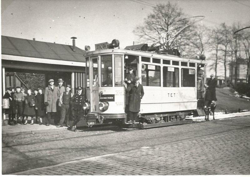 Enschede had vroeger geen stadstrambedrijf maar een interlokale lijn in oostelijke richting naar de Duitse grens bij Glanerbrug. Deze lijn werd in 1908 geopend. De Twentsche Electrische Tramweg Maatschappij (TET) kocht in tegenstelling tot veel andere bedrijven de motorwagens niet in Duitsland maar in eigen land: in Den Haag bij Pennock en in Rotterdam bij Allan, negen in totaal. Veel van de aanhangwagens waren tweedehandsjes. Deze foto van motorwagen 1 is gemaakt voor het station in februari 1933, even voor de sluiting. Het lijkt erop dat enige tramliefhebbers zich daarom nog snel met hun geliefd vervoermiddel wilden laten vereeuwigen voor het te laat zou zijn.Foto: R.G. Klomp (1191.070A)