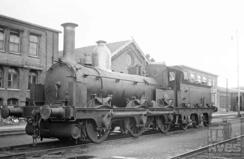 Driemaster-locomotief 2921 werd op 1 juli 1937 door de heer Bonthuis op het terrein van de Wpc Tilburg gefotografeerd. De bijnaam dankt de loc aan de drie gekoppelde assen waarmee zij is uitgerust. Gebouwd in Engeland bij Beyer Peacock & Co, werd zij in 1875 bij de Staatsspoorwegen in dienst gesteld. Na 62 jaar trouwe dienst kan er wel eens wat mankeren natuurlijk (509.005C).