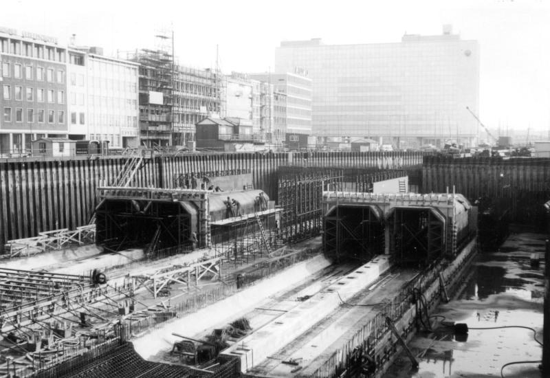 Bouwdok aan het Weena. Op de achtergrond de nog bestaande huizen aan de Delftsestraat. Nu staan op de plek van het bouwdok het hoofdkantoor van Unilever en het ING-gebouw.Fotograaf onbekend; verzameling SNR