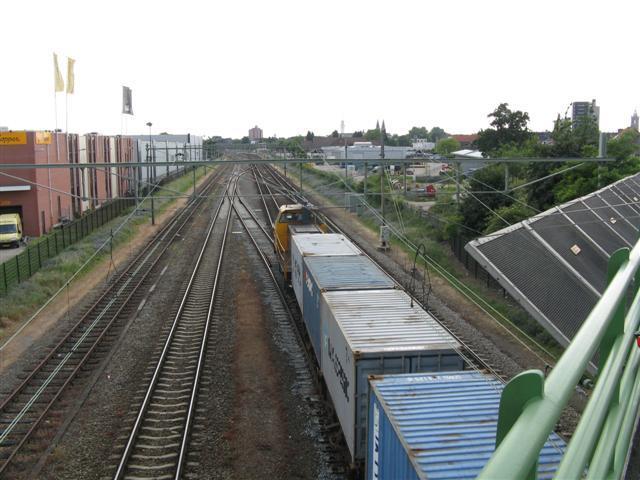 Een containertrein nadert over linkerspoor station Roermond en zal spoedig naar het rechterspoor overlopen.Foto genomen vanaf het viaduct in de Venlose weg.