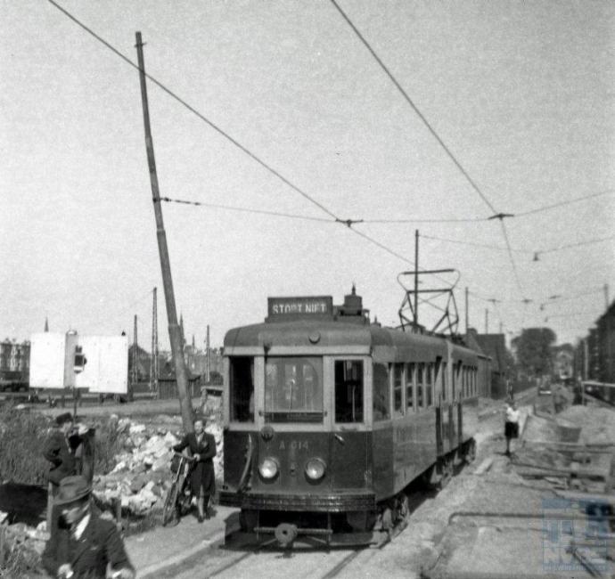 In augustus 1945 kon je ook weer met de NZH-tram van Den Haag naar Leiden reizen. De foto laat duidelijk zien dat de omgeving van de tram nog niet genormaliseerd is. Er was slechts enkelspoor en veel ruimte voor wandelaars en fietsers bleef er niet over als de tram er door moest. Naast de A614-613, een van de fraaie harmonicatrams die het Haarlemse Beijnes in 1932 had geleverd, zien we een diepe bomkrater: hier was een V2-raket ingeslagen na een mislukte lancering. (foto 130.328; 8-8-1945)