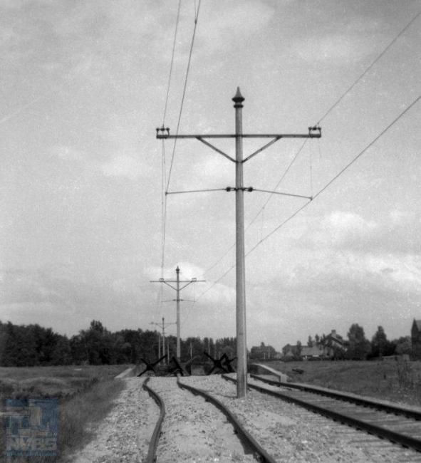 Ook de trambedrijven hebben veel te lijden gehad van de oorlog. Bij de HTM lijn I² naar Leiden hebben mensen in de Hongerwinter op sommige plaatsen de dwarsliggers gesloopt om op te stoken, zoals hier bij de halte Laboratoria in Leiden. Maar ook al zouden die er nog wel liggen, de tankversperring in de vorm van ‘egels' iets verderop had doorrijden sowieso verhinderd. (foto 109.802; 14 juni 1945)