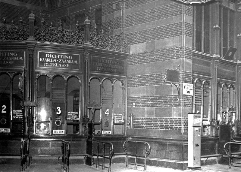 De loketten in de hal van Amsterdam CS; voor de verschillende richtingen had men aparte loketten. Dit stond wel bekend als ′het orgel′.De foto is gemaakt omstreeks 1930. Deze loketten zijn omstreeks 1950 verdwenen.