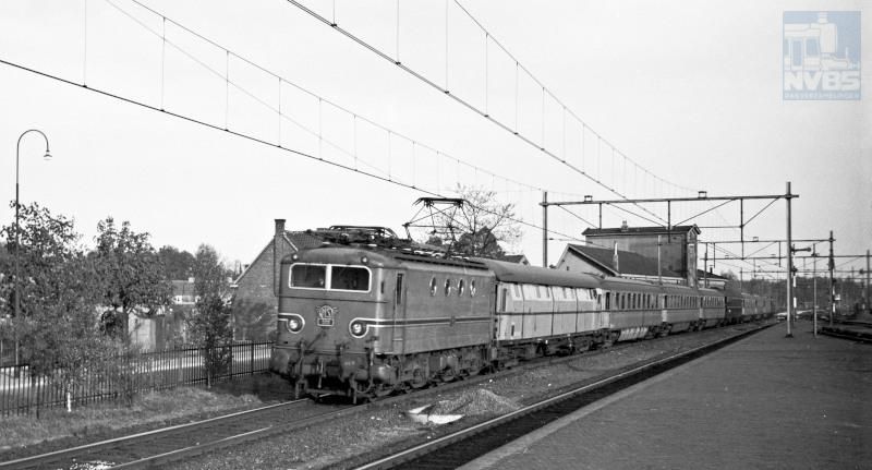 "Exprestrein" 38 (Amsterdam-Maastricht), bestaande uit elektrische locomotief NS 1111, een bagagewagen type DV, rijtuigen plan D en een CIWL restauratierijtuig tijdens de passage van Boxtel.Boze tongen beweren dat de kleur turquoise van dit materieel vooral was gekozen op aandringen van de echtgenote van NS-directeur F.Q. den Hollander, en dat de onderhouds­werkplaatsen er een hekel aan hadden omdat deze kleur heel moeilijk constant te houden was.Datum: 24 mei 1951