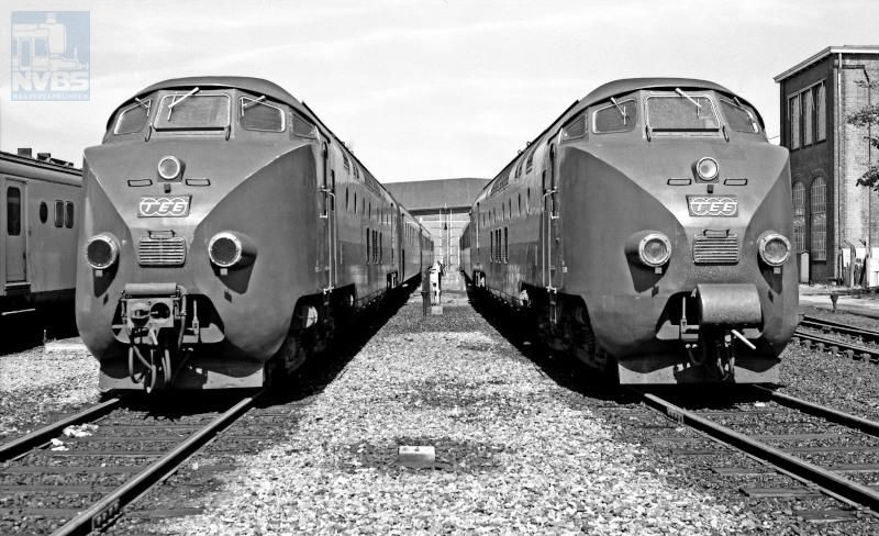Treinstellen voor de TEE-verbinding "Edelweiss" Amsterdam-Zürich. De Trans-Europ Express was een netwerk van snelle internationale verbindingen, ingesteld in de jaren 1950 op initiatief van NS-directeur F.Q. den Hollander.Het gebruik van diesels maakte het loc-wisselen aan de grenzen overbodig, en daarnaast sloten de elektrische netten uit de verschillende landen nog niet op elkaar aan.De beide 4-delige diesel-elektrische treinstellen zijn hier in 1974 gefotografeerd bij de dieselloods van de voormalige Lijnwerkplaats te Utrecht.