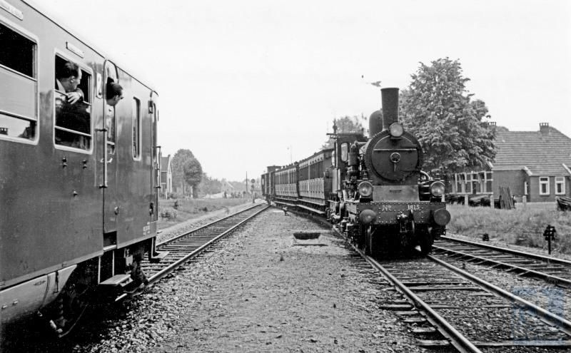 Deze foto is gemaakt tijdens de NVBS Dieselrondrit 1953, op 14 juni 1953, met de toen gloednieuwe "Blauwe Engelen" (diesel­motor­rijtuigen) NS DE1 25 en 26 lijnen in Noord-Oost Nederland werden bereden. Rechts de diensttrein, die in die tijd met stoom reed.