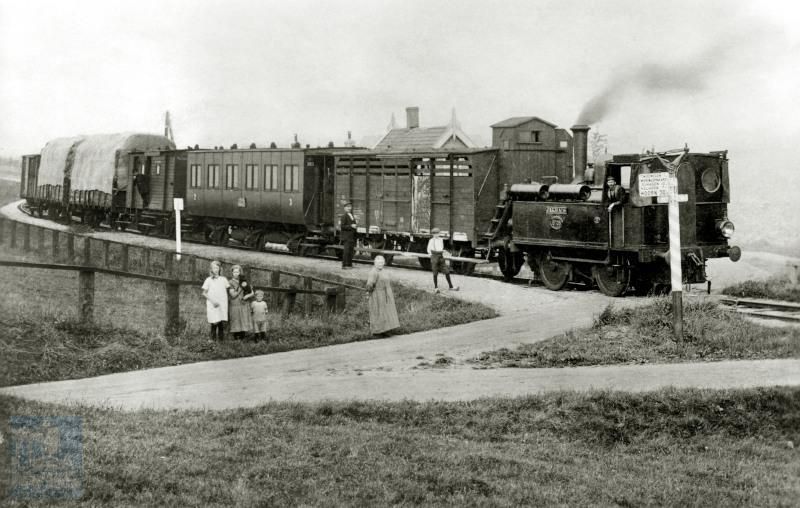 Een gemengde trein (zowel reizigers- als goederenvervoer) met loc 6708 "Jakhals" te Driemolens aan de lijn van Schagen naar Wieringerwaard. De goederenwagen achter de loc is een veewagen; op de wagen zit een remmershuisje. In de tijd dat treinen nog geen doorgaande remleidingen hadden, bevonden zich in dergelijke huisjes remmers die zonodig een rem konden aandraaien om de trein tot stilstand te brengen. Achter de veewagen een lokaalspoorrijtuig 2e en 3e klasse serie NS BCl 301-304, oorspronkelijk BC 1-4 van Stoomtramweg Mij West Friesland (SMWF). Naast de remmers bevond zich in de bagagewagen achterin de trein nog een conducteur.