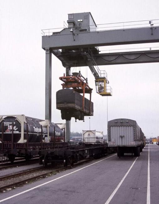 Een oplegger wordt aan boord van een goederentrein gehesen.