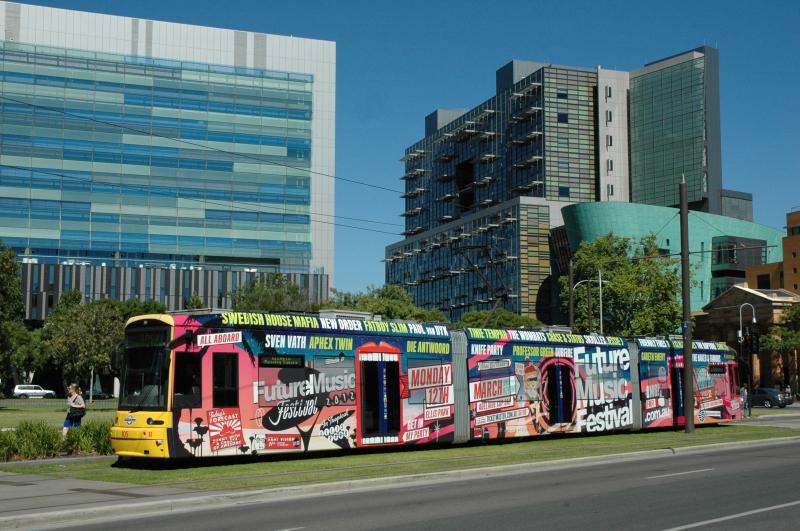 Om de kosten van het gratis vervoer in de binnenstad te dekken wordt op grote schaal totaal reclame gevoerd. De 105, hier op het Victoria Square is wel heel bont uitgedost met reclame voor een muziek festival.