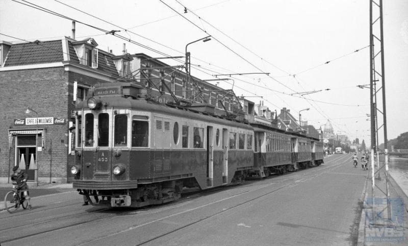 Terug naar Haarlem en de NZH. Langs de Leidschevaart rijdt de A453 met de aanhangrijtuigen B66, B65 en B67, in de buurt van de remise. Het is onduidelijk of het een diensttram betreft of een remisetransport. De motorwagen is een van de smalspoor ‘Boedapesters' van de firma Ganz uit 1924. De aanhangwagens zijn aanmerkelijk ouder: zij zijn afkomstig van de ESM en dateren van 1905. (J.A.Bonthuis; NVBS-fotonummer 130.420)