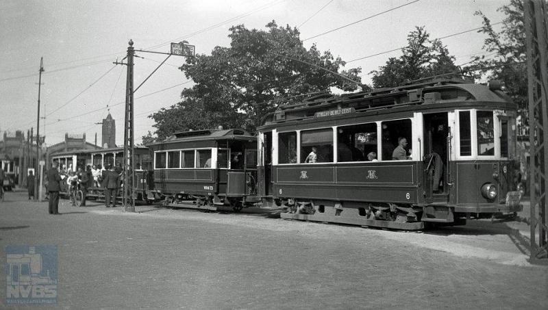 Deze foto werd gemaakt op Tweede Pinksterdag, die in 1935 viel op 10 juni. Een extra drukke dag voor de NBM, die ook de voormalige paardentramrijtuigen moest inzetten om de drukte aan te kunnen. Bij het beginpunt in Zeist staat emr. 6 met de aanhangwagens 23, 28 en 16 klaar om naar Utrecht te vertrekken. Het eerste en laatste aanhangwagentje zijn na de opheffing in 1949 naar het Nederlands Spoorwegmuseum verhuisd waar de 16 nog steeds binnen is te bewonderen. De 23, sinds 1944 met gesloten balkons, werd in 2007 ondergebracht bij de Tramwegstichting in Overloon. De foto is van W.D.J.Cramer. (NVBS-fotonummer 119.144)