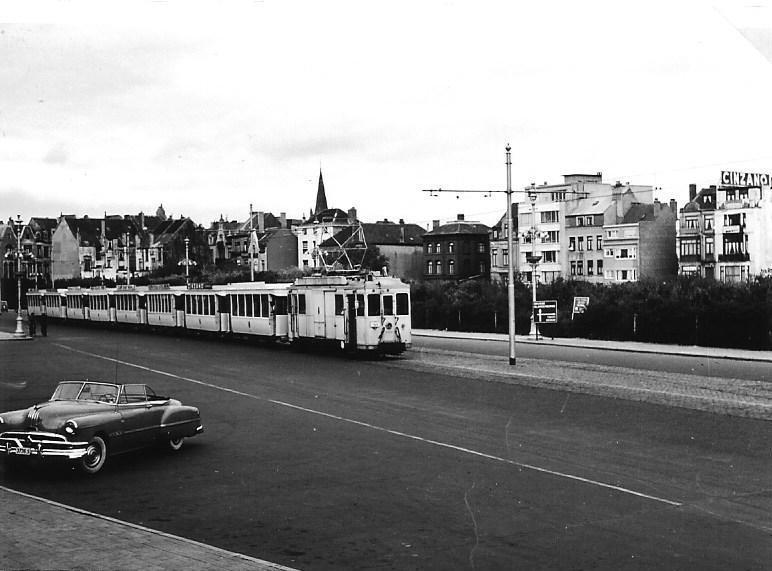 Tot slot het record op dit gebied, tenminste voor zover de samensteller van deze reeks heeft kunnen nagaan: een tram met maar liefst acht aanhangwagens. Ook hiervoor gaan we naar de Belgische kustlijn van de NMVB. Op de foto trekt motorwagen 10019 achtereenvolgend de aanhangers 8891, 8886, 8871, 8867, 8769, 8771, 8888 en 8889. Het ‘transport' vindt plaats op de Koningin Astrid Boulevard te Oostende. Het betreft hier een Kindertram. Tijdens de zomermaanden liet de Stad Oostende deze trams rijden van het centrum naar een grote speeltuin in de duinen buiten de stad. ′s Ochtends heen, eind van de middag terug.De datum is 5 juli 1955 en de fotograaf E.J.Bouwman (NVBS-fotonummer 1332.0006)