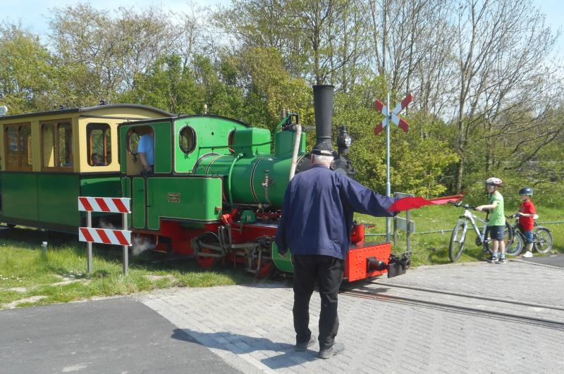 Kort na vertrek kruist de lijn de toegangsweg naar het Valkenburgse Meer; de conducteur houdt met de rode vlag het verkeer tegen zodat de trein kan passeren.