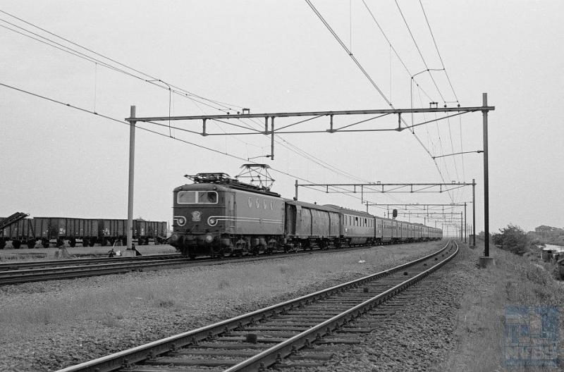 Het standaardbeeld van een reizigerstrein op De Oude Lijn in de zestiger jaren: deze 1100 met plan E-rijtuigen. Loc 1105 komt in 1950 bij NS op de rails als trekkracht voor zowel personen- als goederentreinen. De serie van zestig stuks is in Frankrijk gebouwd door Alsthom. De laatste gaan pas tegen de eeuwwisseling uit dienst. De 1105 bevindt zich ter hoogte van Noordwijkerhout en is op weg naar Amsterdam CS. In de bagagewagen vooraan werden hoofdzakelijk kranten vervoerd. De foto is door R. Ankersmit genomen op 8 juni 1961 (NVBS-fotonummer onbekend).