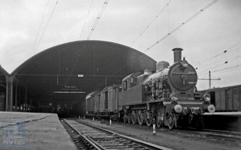 Onder de kap van station Rotterdam DP (Delftsche Poort), de voorloper van het Centraal Station, staat stoomlocomotief 6007 met een trein klaar voor vertrek. Het is niet goed te zien of het een personen-of goederentrein betreft. De 2C2-locomotief, uit een serie van 26 stuks, werd gebouwd door het Britse Beyer, Peacock & Co. Ltd. die daar tien jaar over heeft gedaan, namelijk van 1906 tot 1916. Deze serie kwam oorspronkelijk in dienst bij de SS. H.G. Hesselink maakte de foto op 23 februari 1935 (NVBS-fotonummer 170.216).