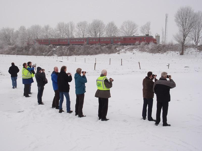 Op de foto is de excursietrein, de rode plan U 113, op 30 december 2010, in de sneeuw zichtbaar, terwijl enkele deelnemers vanaf het bevroren Stadskanaal bij Bareveld toekijken.