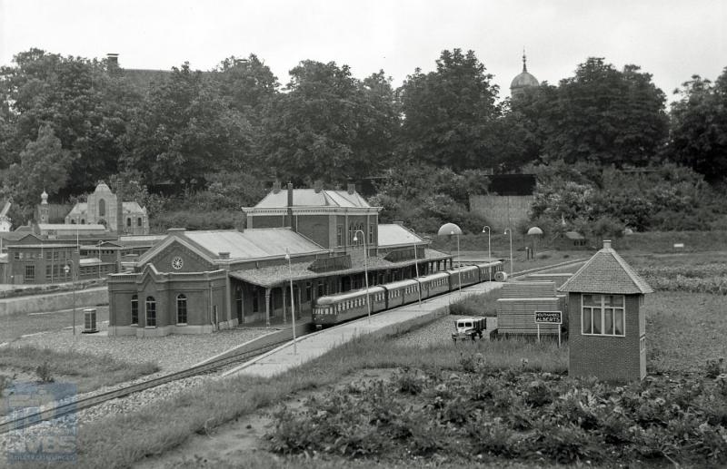 In 1954, het jaar waaruit deze foto stamt, was de Zeeuwse lijn nog niet geëlektrificeerd. Er staat dan ook een dieselvijf aan het perron van station Middelburg. We bevinden ons in de evenknie van Madurodam, Miniatuur Walcheren geheten.