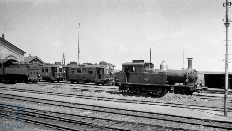 We werpen een blik op het locomotievendepot van Vlissingen. We zien stoomlocomotief 7118 staan en een paar omC's uit de serie 901-908 die op de lijn door de zak van Zuid-Beveland reden.