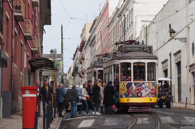 Wagen 563 op weg naar Prazeres aan de ander kant van de stad met direct erachter wagen 575 met de bestemmingaanduiding M.Moniz. Goed zichtbaar is dat lijn 28E met een trolleystang rijdt.