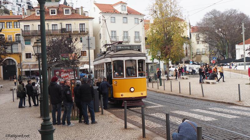 Op het Largo das Portas do Sol lijkt de tram, wagen 560, alle ruimte te hebben, al staan er meer reizigers te wachten dan er in kunnen.