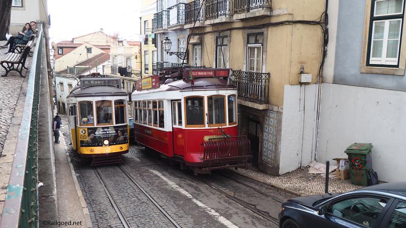 Het past net. Wagen 11 (rood) en 555 kruisen elkaar in de Calçada de São Vicente voor een van de vele opvallende huizen met gietijzeren balkonhekjes en blauwgetinte tegelbekleding.