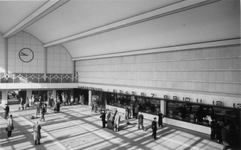 De hal in de beginjaren met aan de rechterkant de loketten, links daarvan de ingang van de reizigerstunnel, en rechts (niet op de foto) de bagage-tunnel.Foto 530-528D uit de verzameling van de SNR, gemaakt door J. Bonthuis op 2 october 1957.