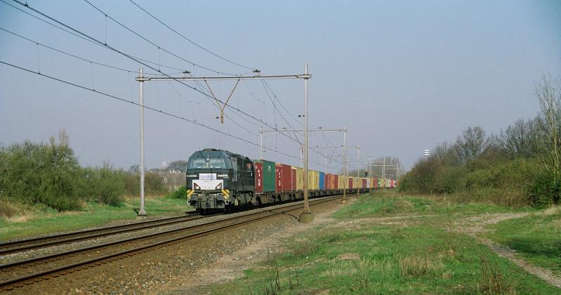 Het struikgewas rechts is opgeschoten op de plaats waar voorheen het station gestaan heeft. Alleen enkele hekken doen vermoeden dat hier ooit een station geweest is. Dieselloc 500 1608 van Rurtalbahn trekt een containertrein naar Duitsland.