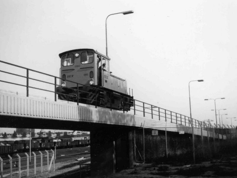 RET metroloc 1002 op het viaduct naar de remise Hilledijk; onder het viaduct door zijn goederenwagens te zien op het NS-emplacement Feijenoord.Foto Wout Jansen, 28 september 1967
