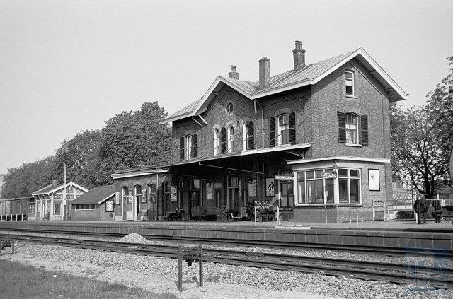Gezicht op de sporen, perrons en het stationsgebouw van Goor (km 30,148), gefotografeerd vanaf de zuidoostelijke zijde. 21 april 1960. (Foto: R. Ankersmit)